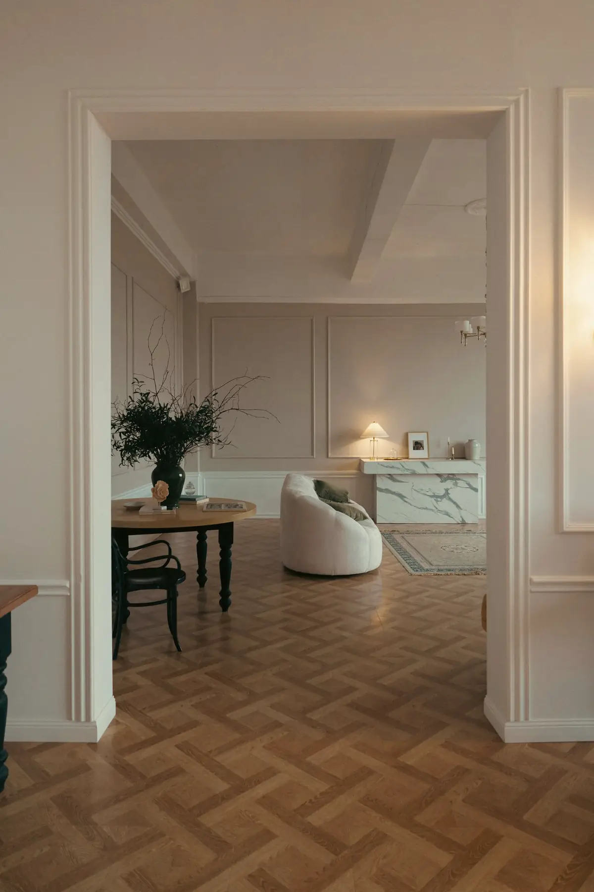 Enfilade de pièces claires, portes ouvertes et parquet à bâtons rompus