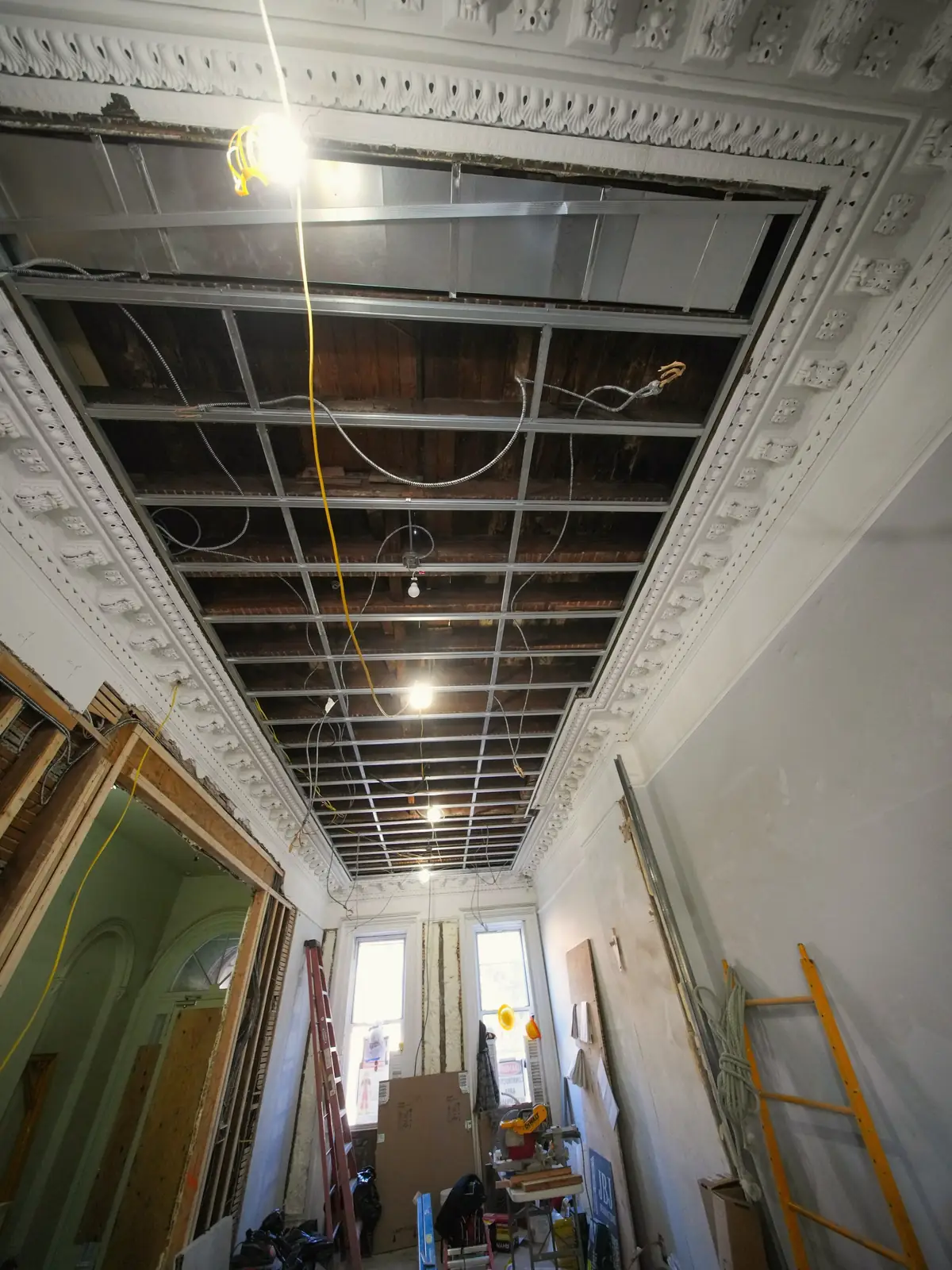Couloir d’immeuble ancien en rénovation, plafond ouvert sur son ossature