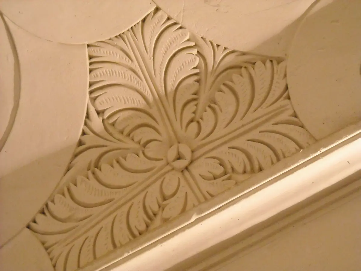 Détail d’une gypserie provençale : feuillages en plâtre sculpté dans une cage d’escalier