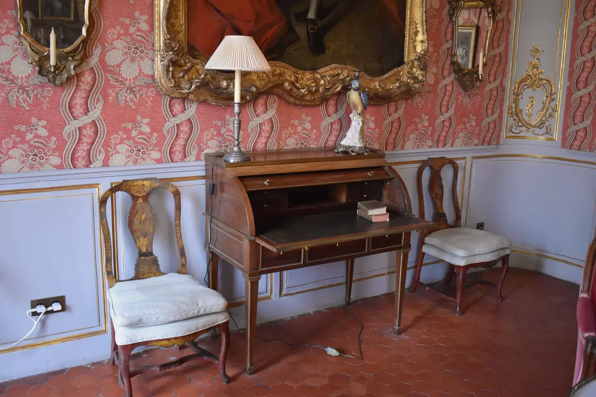Chambre de l’hôtel de Caumont, à Aix : tomettes au sol, lambris peints et tenture rouge