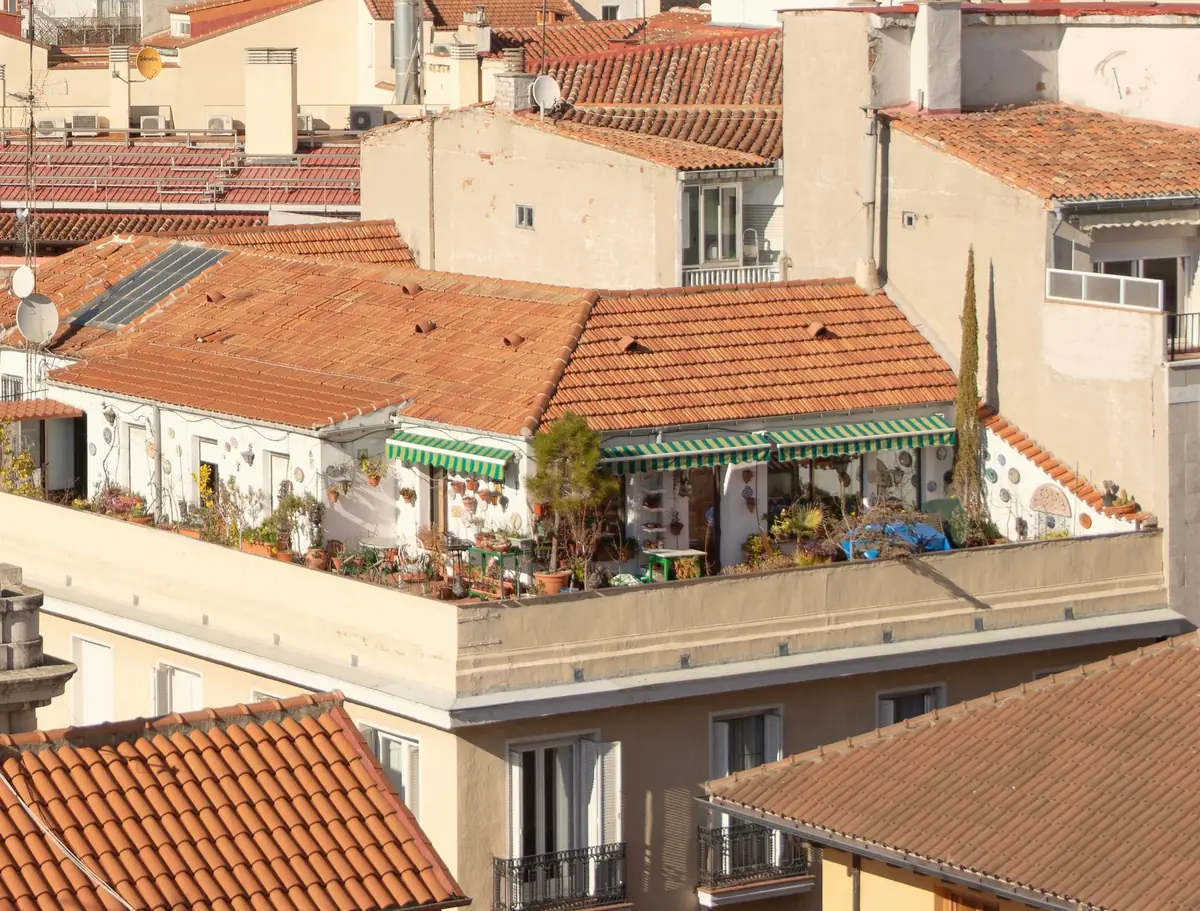 Toits de tuiles et terrasses aménagées sur les immeubles d’une ville méditerranéenne